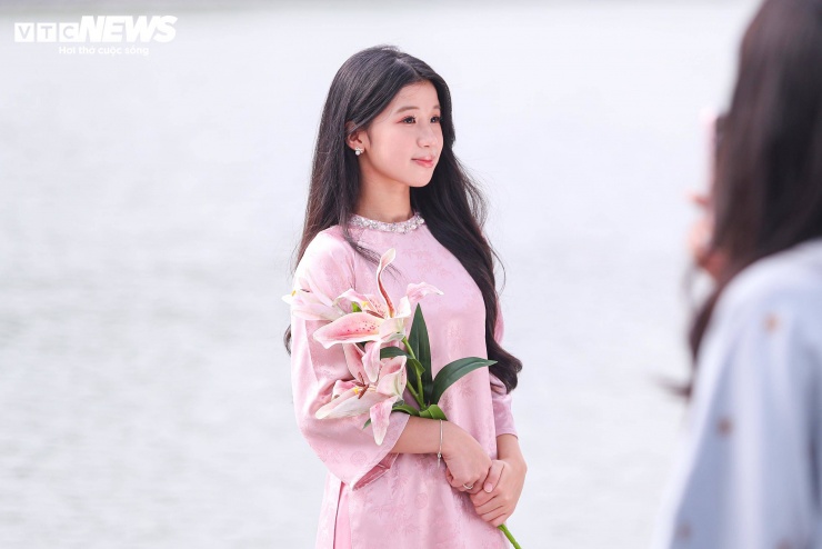 Dưới nắng vàng ấm áp, nhiều thiếu nữ Hà Nội rạng rỡ tạo dáng bên Tháp Rùa cổ kính, làm nổi bật vẻ duyên dáng của tà áo dài truyền thống.