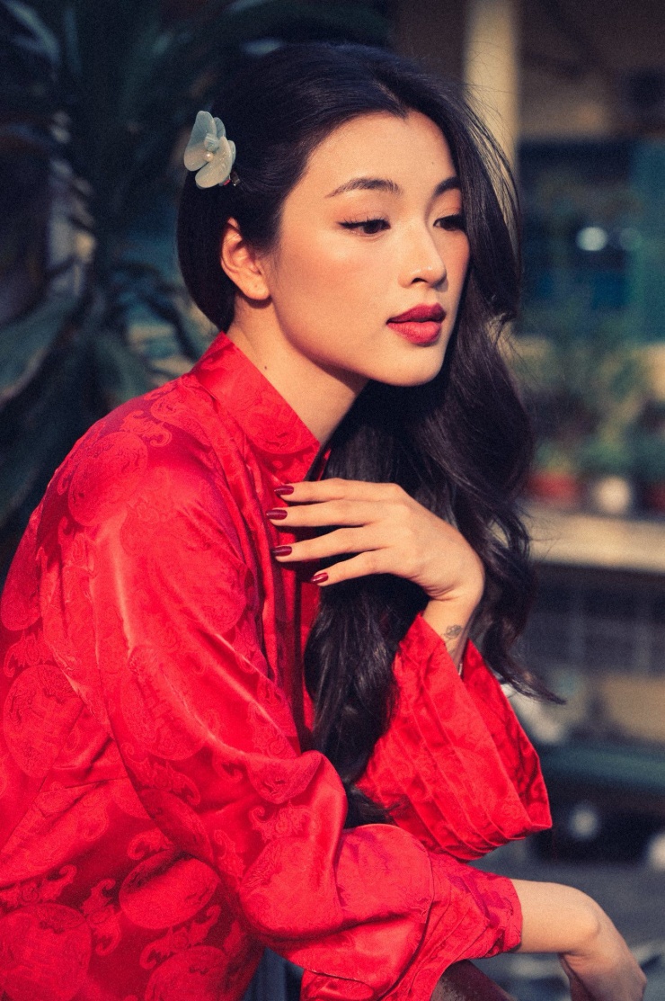 Trong loạt hình dạo phố, Lan Thy lựa chọn áo dài đỏ truyền thống với phom dáng tối giản nhưng tinh tế. Sắc đỏ nổi bật giúp tôn lên làn da trắng mịn và những đường nét gương mặt thanh tú của cô.