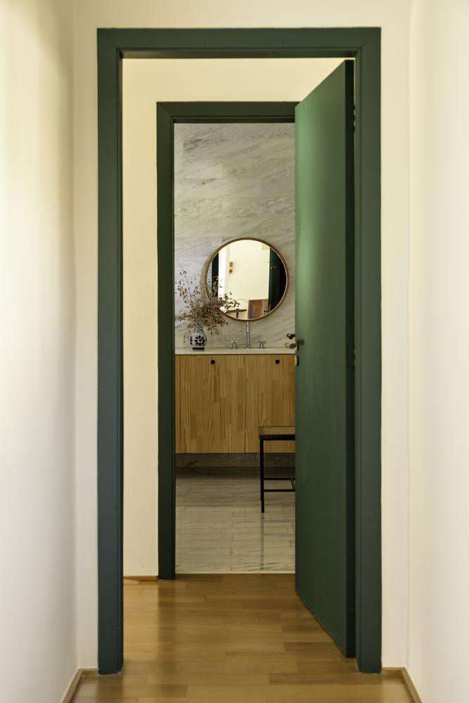 Phòng tắm được cải tạo lại với vẻ đẹp hiện đại, kết hợp giữa gỗ và đá ốp tường sáng màu. Nguồn: Archdaily