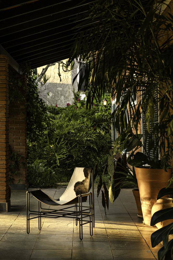 Góc hiên nhà yên tĩnh với chiếc ghế da bò, nơi thời gian như ngừng trôi. Nguồn: Archdaily