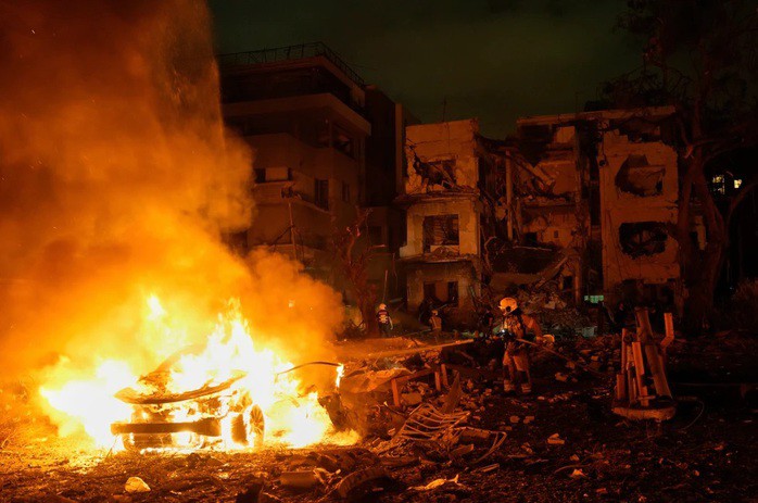 Lính cứu hỏa ở TP Tel Aviv - Israel dập đám cháy do một tên lửa Iran gây ra vào ngày 16-6-2025, trong khoảng thời gian mà Israel và Iran xảy ra xung đột - Ảnh: AP