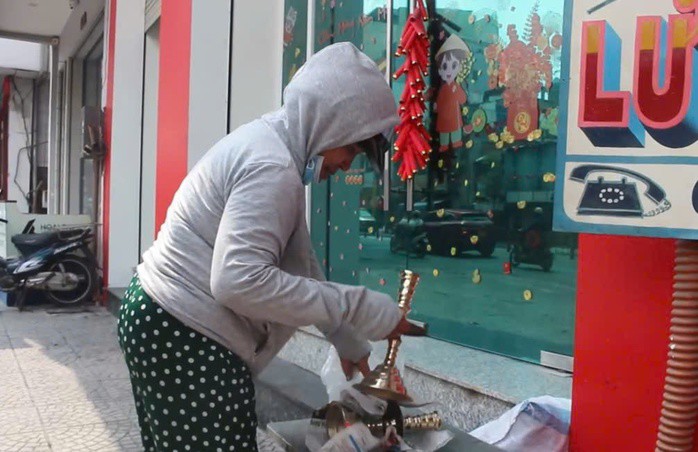 Bà Phượng nhận cặp lư đồng vừa đánh bóng xong