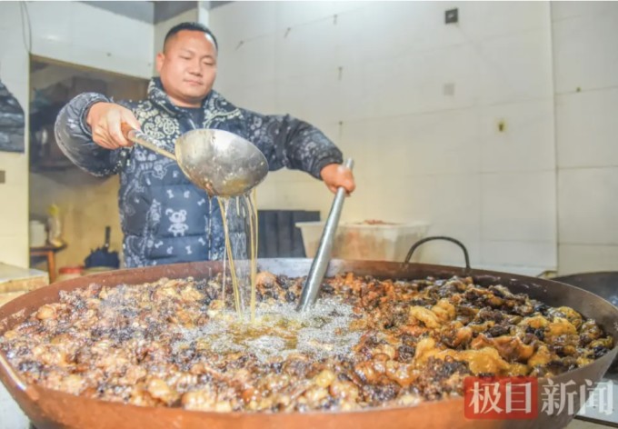 Liu Yang đang nấu mỡ bò tại một cửa hàng ở huyện Gong'an. Ảnh: Jimu News