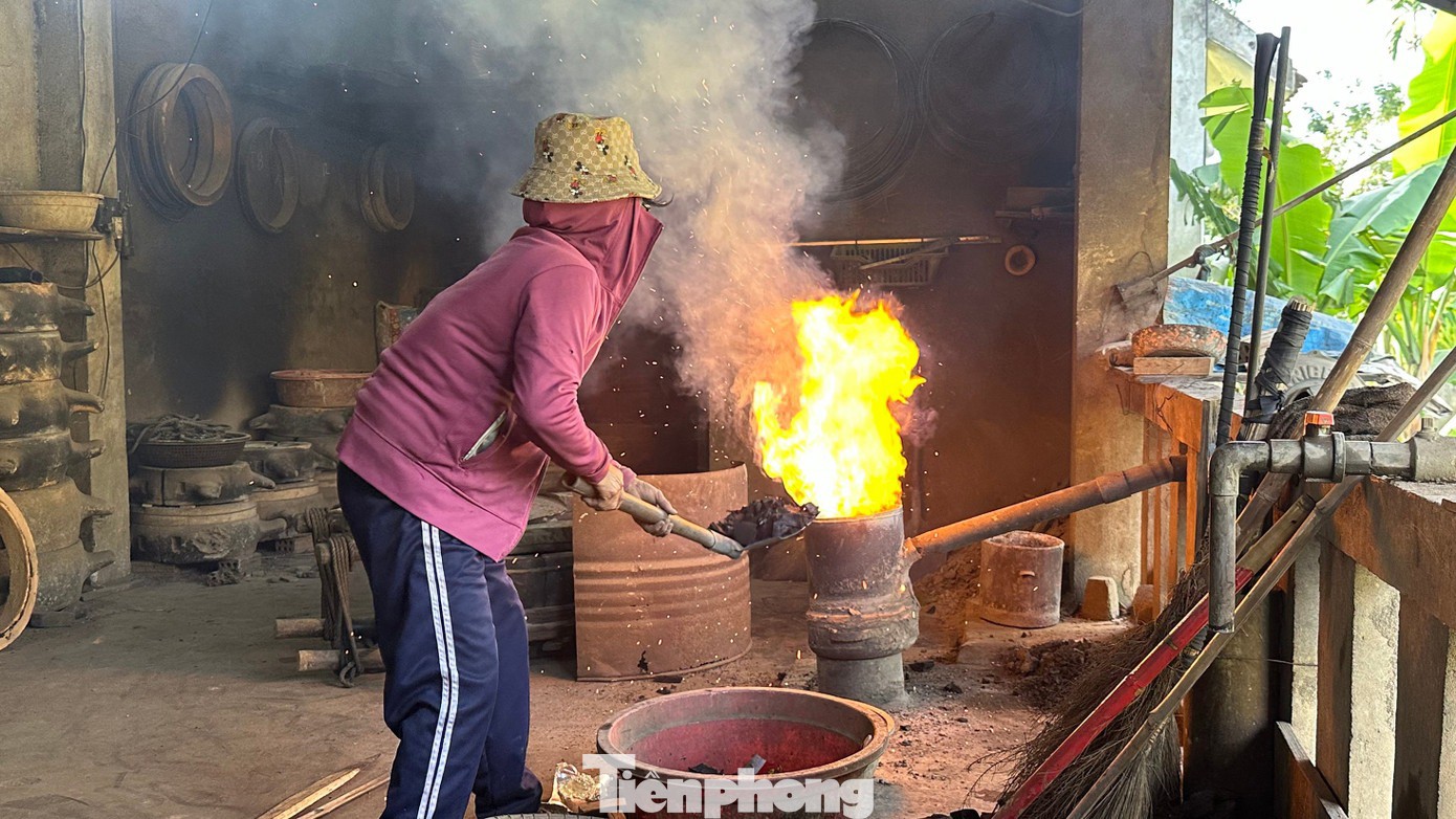 Đồng nguyên liệu được đưa vào lò nấu. Người thợ kiểm soát nhiệt độ bằng kinh nghiệm, quan sát màu sắc và độ chảy của kim loại để xác định thời điểm rót đồng thích hợp. Ảnh: Thảo Vy – Thùy Dương