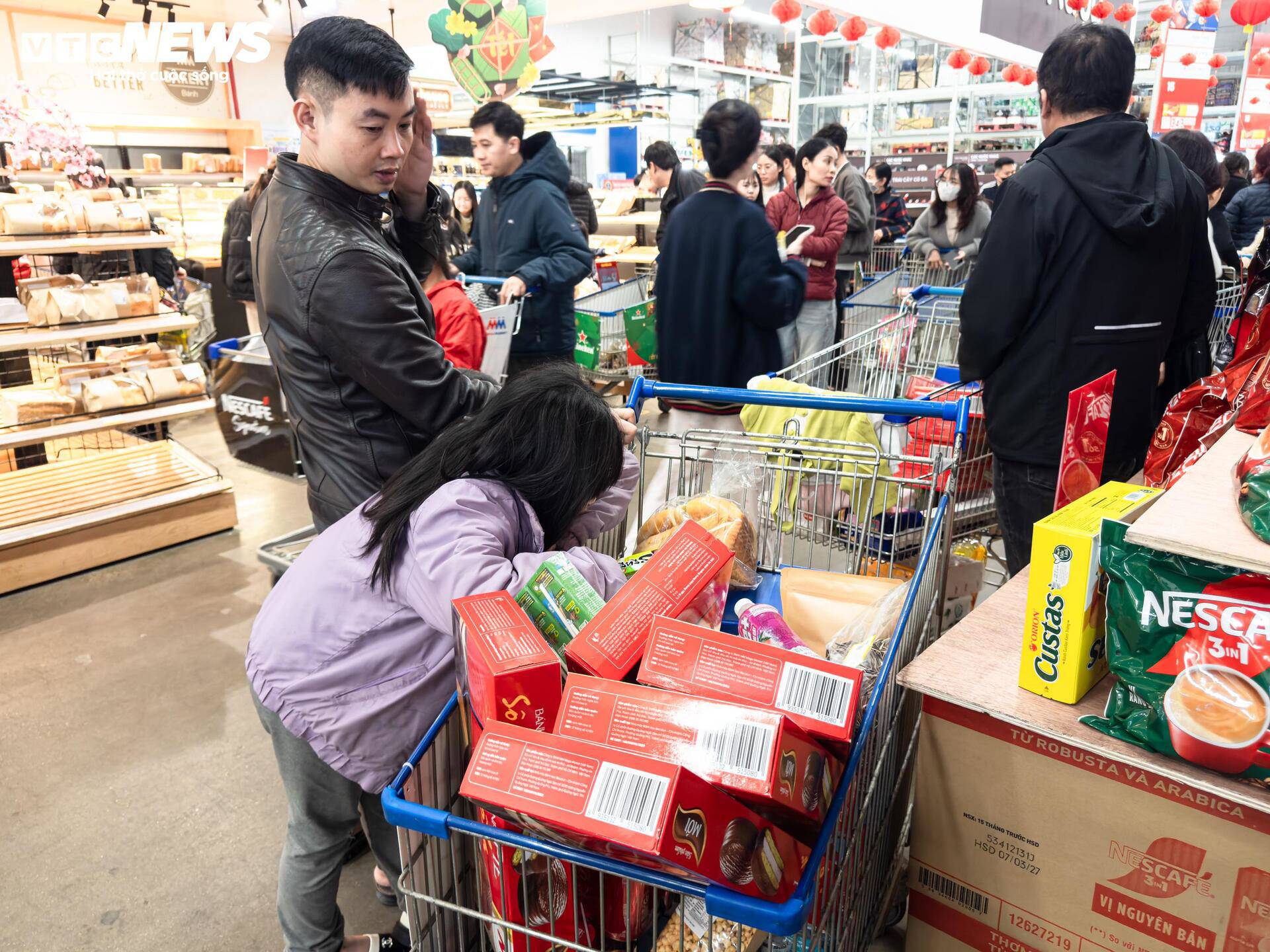 Những chiếc xe đẩy đầy ắp hàng hóa di chuyển khó khăn trong siêu thị.