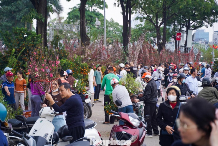 Chiều 14/2 (tức 27 Tết Bính Ngọ), biển người đổ về các chợ hoa Xuân khu vực Mỹ Đình, Lạc Long Quân... khiến không khí mua bán tại đây trở nên náo nhiệt hơn bao giờ hết.