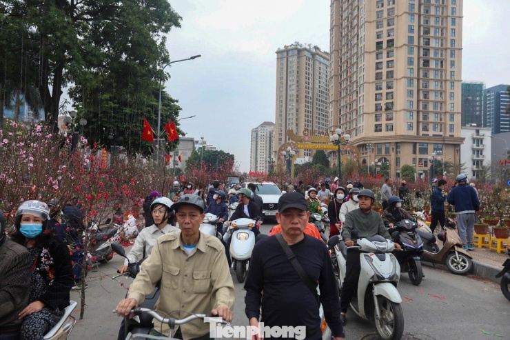 Dòng người ken đặc, di chuyển chật kín chợ hoa khu vực Tây Hồ. Khung cảnh mua bán sầm uất, tấp nập bao trùm các chợ hoa ngay trong ngày đầu người dân chính thức bước vào kỳ nghỉ lễ.