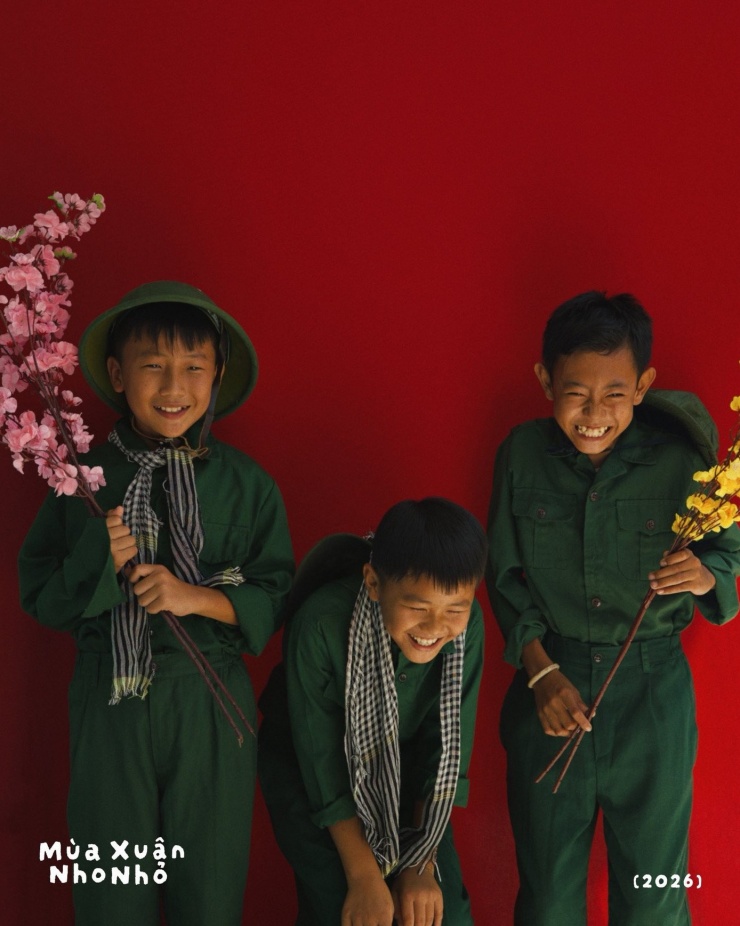 Các em nhỏ mặc quần áo bộ dội và cầm nhành mai, đào... tạo dáng chụp ảnh chân dung.