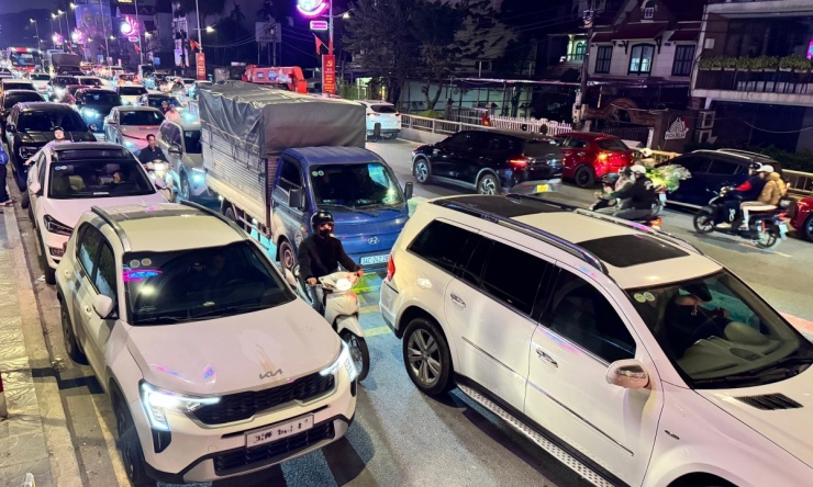 Lúc 23h đêm 15/2 (28 Tết), khoảng 1 km trên đường Âu Cơ gần chợ Quảng An gần như tắc cứng khi phương tiện của người Hà Nội đổ đến mua hoa mỗi lúc một đông.