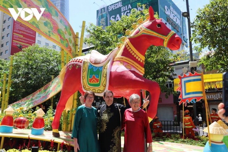 Du khách người Đức, mặc áo dài chụp hình cùng linh vật ngựa