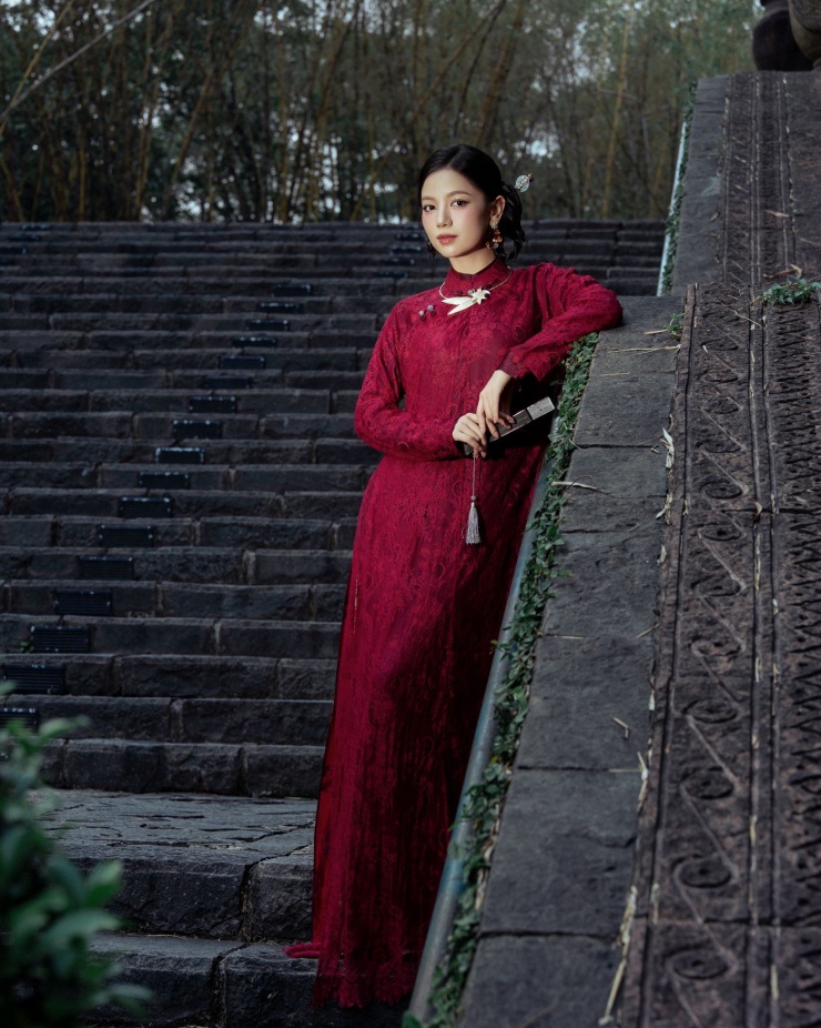 Bộ trang sức với điểm nhấn là chiếc vòng cổ hoa lá tinh xảo cùng phụ kiện quạt nhỏ càng làm tăng thêm sự sang trọng và quý phái, hòa quyện hoàn hảo với sắc đỏ rực rỡ của mùa xuân.