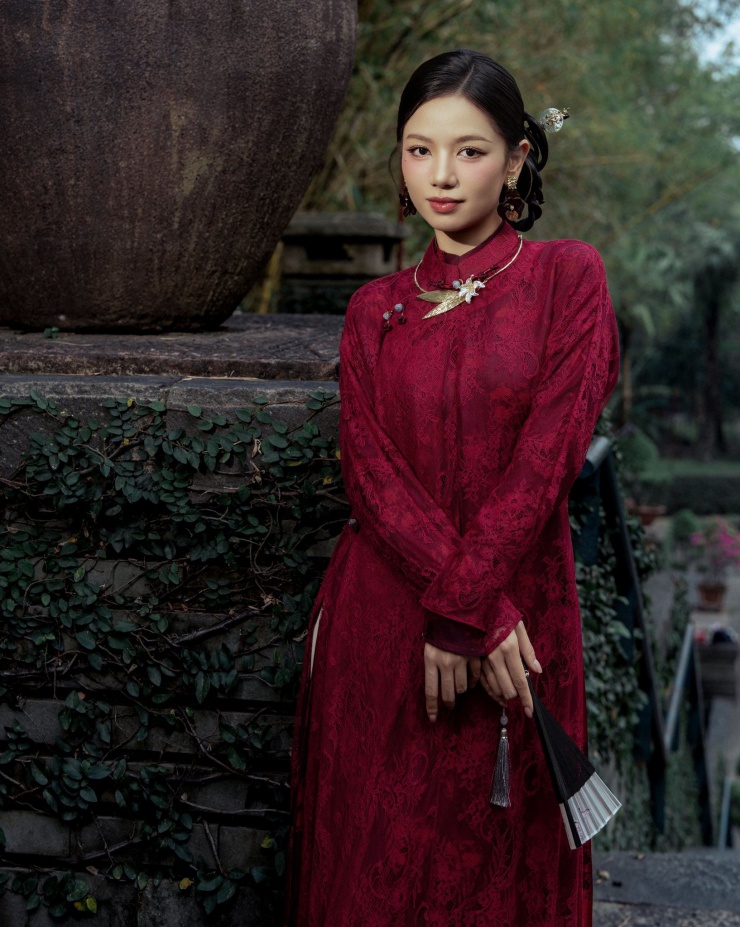 Cô còn khéo léo kết hợp phụ kiện quạt nhỏ, tạo nên tổng thể hài hòa, vừa cổ điển vừa duyên dáng, rất phù hợp với không khí Tết truyền thống đầm ấm và trang trọng.