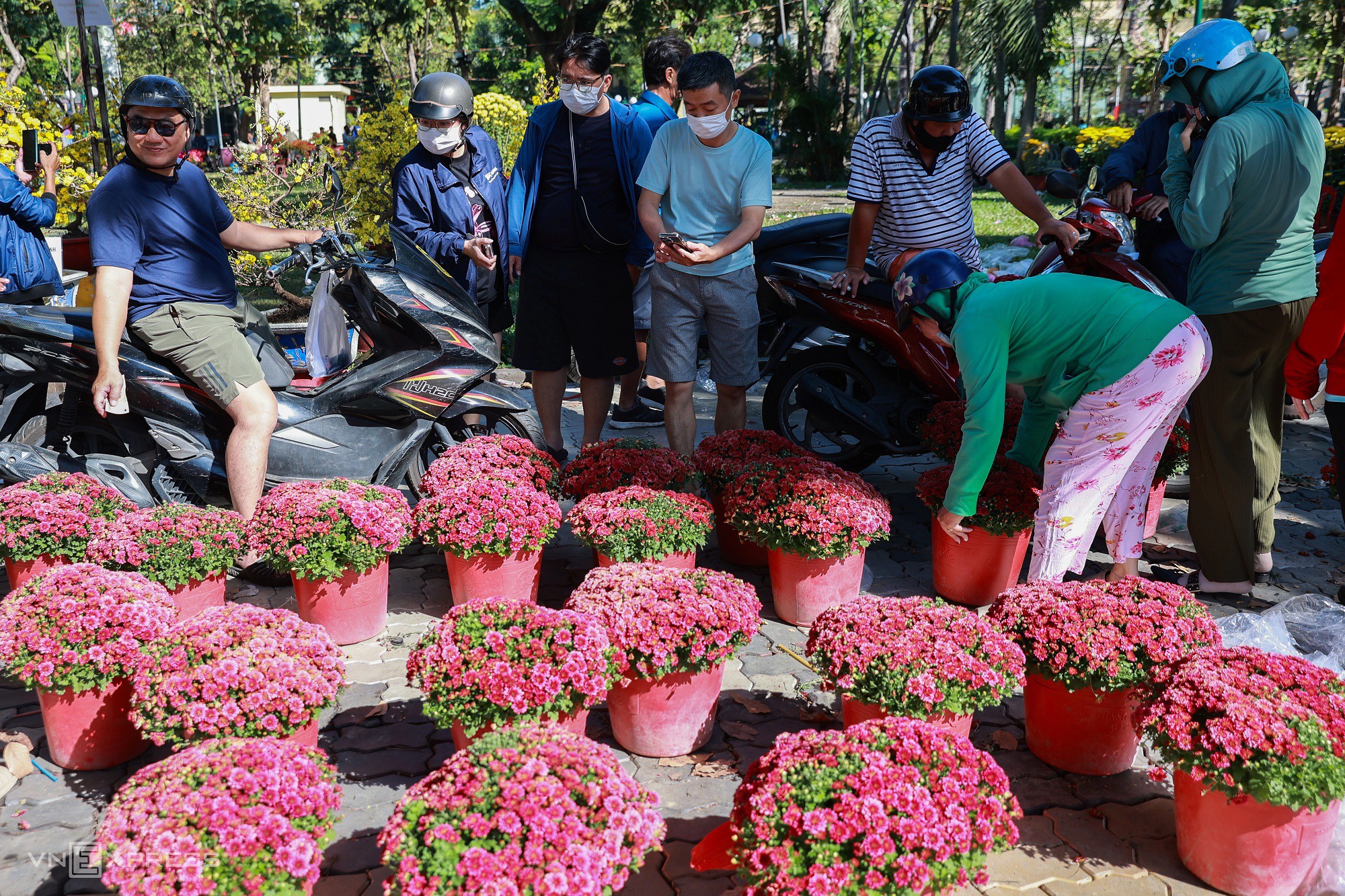 Người dân tấp nập chọn mua cúc mâm xôi Hàn Quốc với giá khoảng 200.000 đồng mỗi cặp. Cạnh đó, ông Văn Địa mua được ba chậu hoa giấy giá 300.000 đồng. "Năm nay giá hoa tương đương mọi năm, thấy cũng khá rẻ nên tôi không mặc cả để ủng hộ người bán", ông nói.