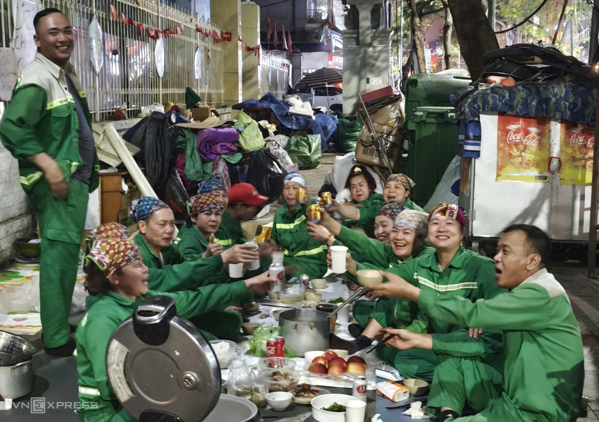 Mâm cơm tất niên trên vỉa hè của công nhân môi trường đô thị trước khi trở lại với công việc. Ảnh:&nbsp;Lê Tân