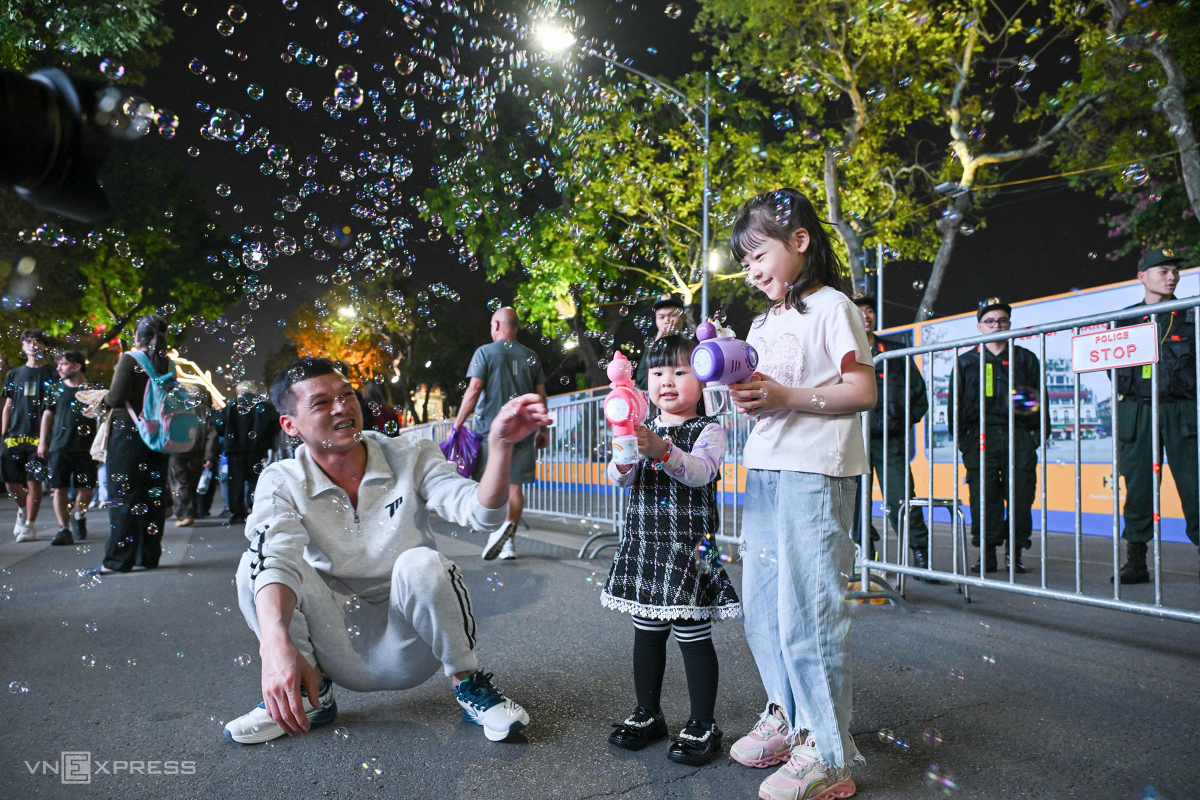 Một gia đình chơi thổi bong bóng trước lúc đón giao thừa. Ảnh: Giang Huy