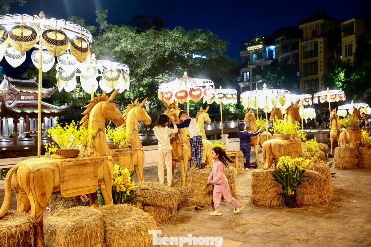 Sau thời khắc giao thừa, hàng nghìn người dân đổ về khu vực Hồ Văn, thuộc quần thể di tích Văn Miếu – Quốc Tử Giám (Hà Nội), xin chữ đầu năm và chụp hình cùng các tác phẩm ngựa độc bản.