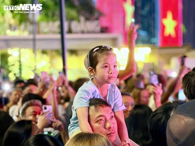 Em bé được ba cõng lên xem pháo hoa.