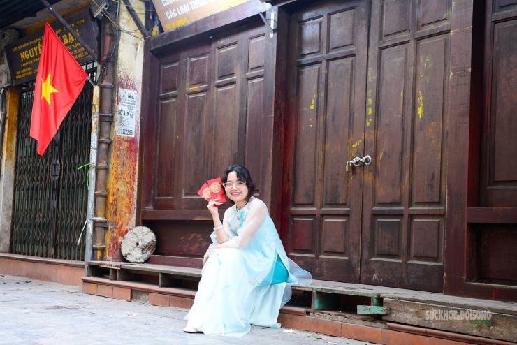 Thiếu nữ trong tà áo dài xanh dịu dàng ngồi bên hiên nhà cổ lưu giữ khoảnh khắc xuân bình yên giữa lòng phố cổ Hà Nội.