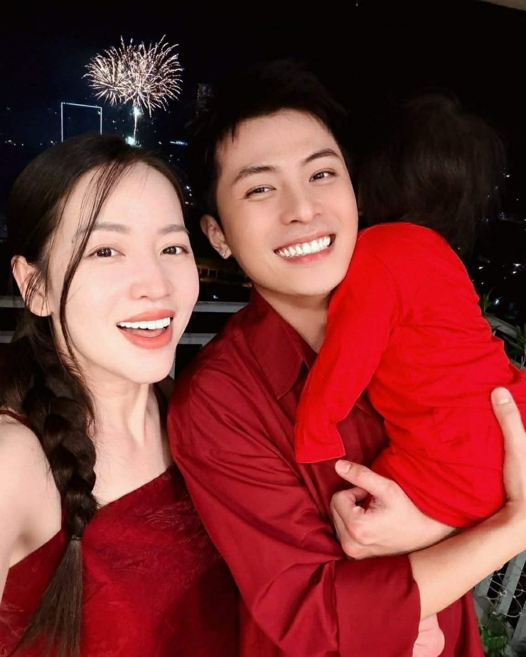 Puka - Gin Tuấn Kiệt bế con gái ra ban công ngắm pháo hoa đón năm mới. Gia đình cặp sao cùng diện trang phục đỏ rực lấy may đầu năm.