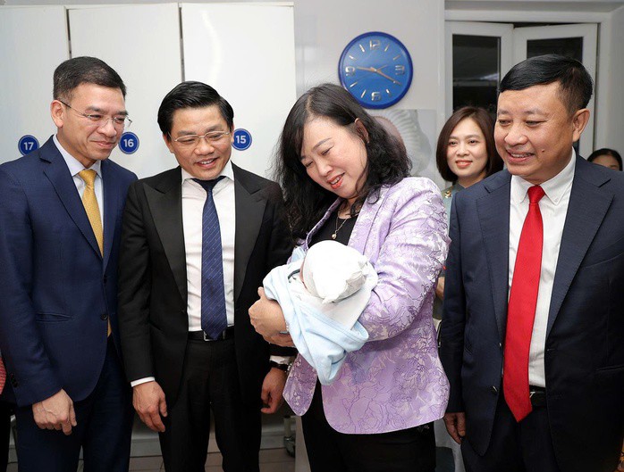 Bộ trưởng Bộ Y tế Đào Hồng Lan bế em bé chào đời tại Bệnh viện Phụ sản Trung ương đêm giao thừa. Ảnh: Trần Minh