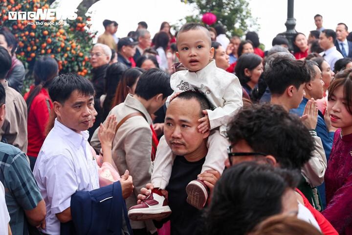 Do lượng người đổ về phủ Tây Hồ đông, nhiều em nhỏ phải ngồi trên vai bố để tránh bị lạc giữa dòng người