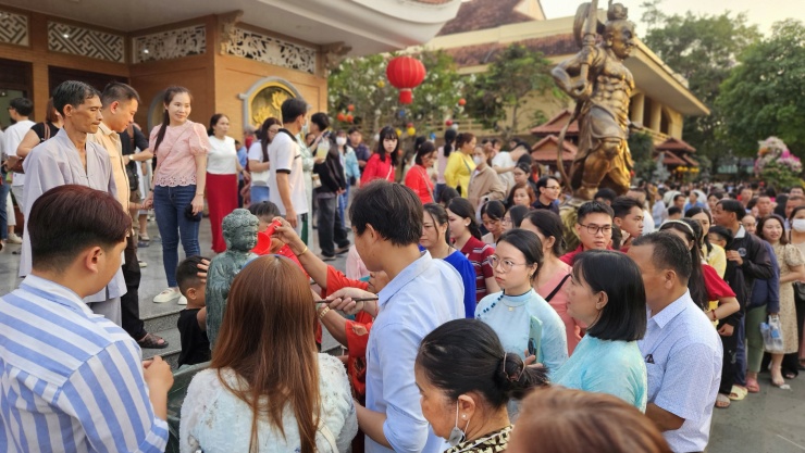 Các Phật tử xếp hàng chờ thực hiện nghi thức tắm Phật.