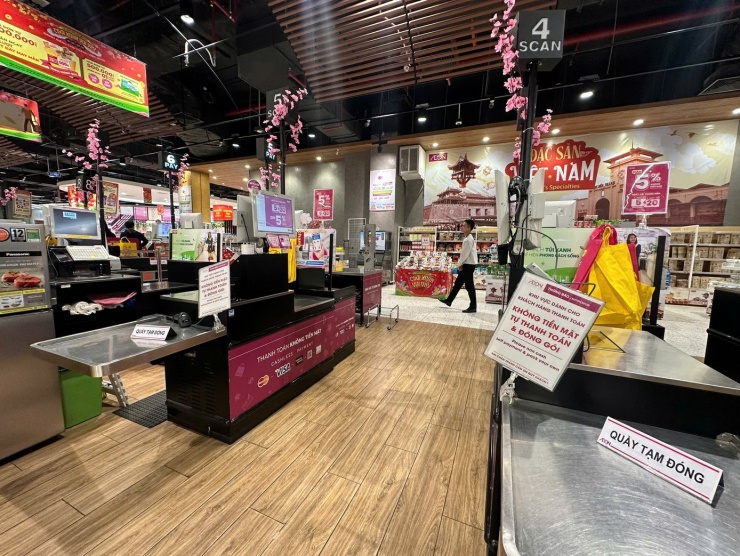 Lượng khách mua sắm còn hạn chế, siêu thị chỉ mở một số quầy thanh toán. Nhân viên làm việc theo ca, luân phiên nghỉ Tết.