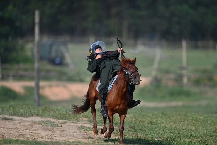 Chiến sĩ Cảnh sát cơ động thực hiện động tác bắn súng khi phi ngựa. Ảnh: K02.