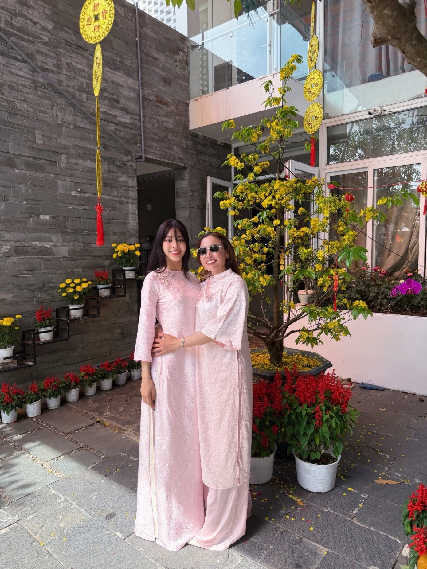 Hoa hậu Tiểu Vy và mẹ mặc áo dài đôi màu hồng khi đi chúc Tết.