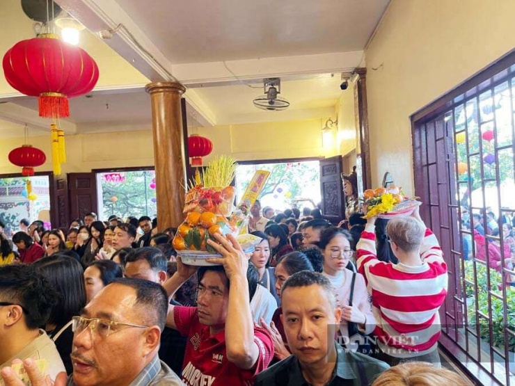 Nhiều người phải bê cao mâm lễ. Sân trước phủ chật kín khách thập phương.&nbsp;Ảnh: Gia Khiêm