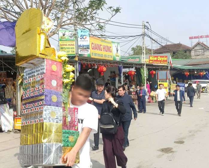 Một người dân mang đồ lễ vào đền ông Hoàng Mười