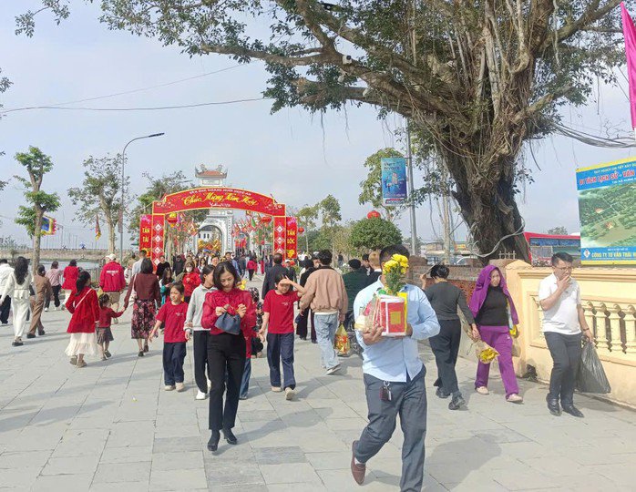 Người dân mang theo đồ lễ, hoa vào đền thắp hương