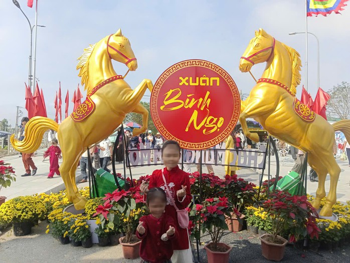 Hai em nhỏ chụp ảnh lưu niệm tại khuôn viên đền ông Hoàng Mười