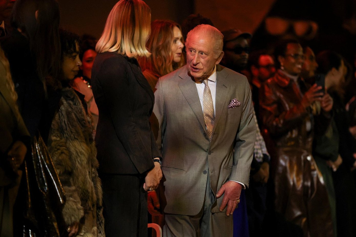 Vua Charles ngồi ở hàng ghế đầu show thời trang, dường như không bị ảnh hưởng bởi vụ bắt giữ em trai. Ảnh: Reuters/Zumapress/Getty Images