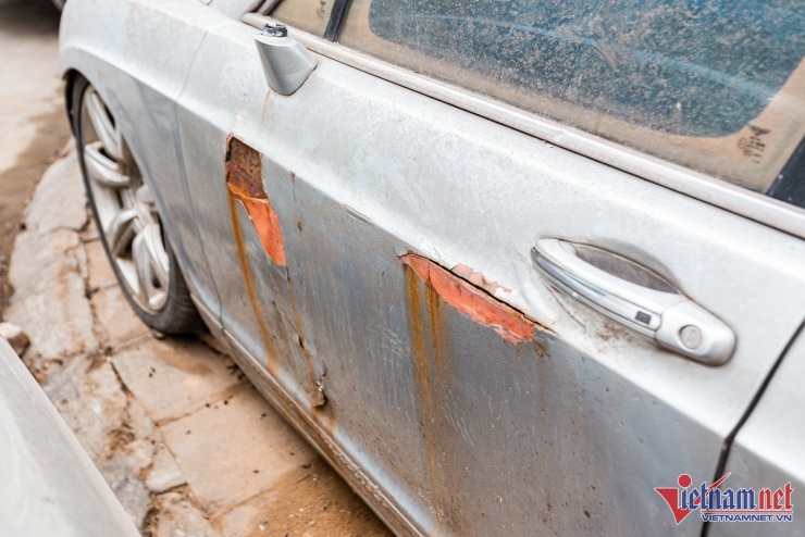 Về tổng thể, ngoại thất chiếc Bentley đã hư hỏng nghiêm trọng. Nước sơn màu bạc bong tróc, trầy xước ở nhiều vị trí, để lộ ra phần thân vỏ hoen rỉ. Bên ngoài phủ đầy bụi bẩn, khó để làm sạch đơn giản do đã “dầm mưa dãi nắng” nhiều năm qua.