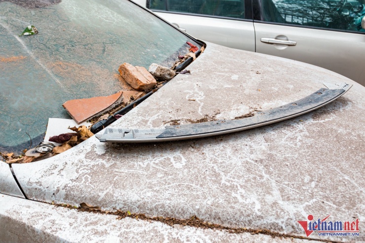 Bên trên kính chắn gió là gạch vỡ, rác và lá cây sót lại. Dựa trên cảm quan bề mặt, có thể thấy những vật này còn mới, nhiều khả năng chỉ được vứt trên chiếc xe sang cách đây không lâu.