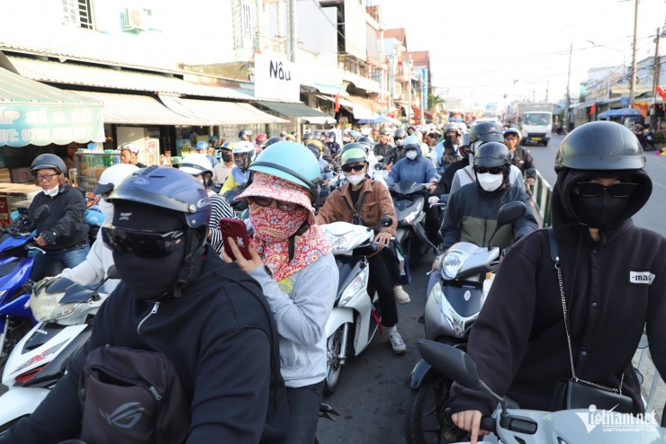 Theo ghi nhận lúc 15h, dòng người và xe cộ theo hướng từ Đồng Nai đi TPHCM nhích từng chút một trong bầu không khí ngột ngạt.