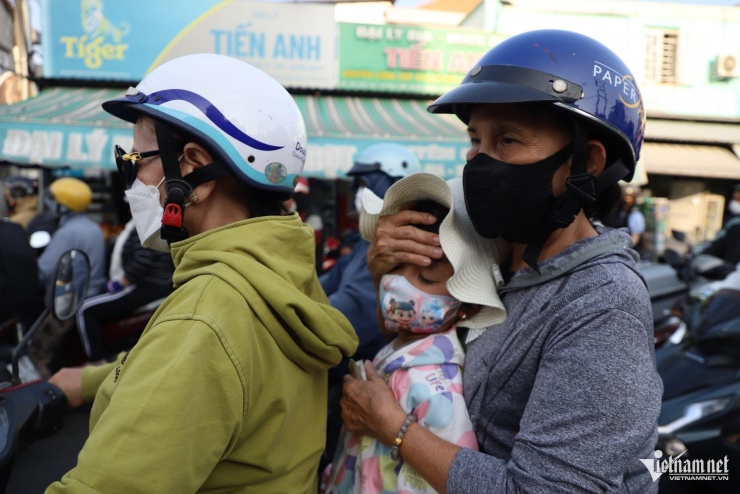 Sau hành trình dài từ quê trở lại TPHCM, nhiều trẻ nhỏ thấm mệt, gục đầu vào vai cha mẹ ngủ trên xe máy khi chờ phà.