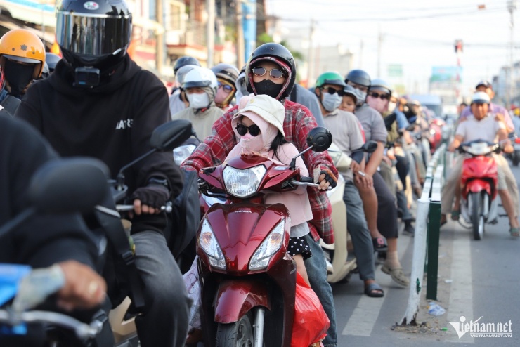 Trên các xe máy, người lớn chở theo con nhỏ, phía trước, phía sau chất đầy balô, túi xách, thùng quà quê; có xe còn buộc thêm cả bao tải, thùng xốp lỉnh kỉnh, khiến việc di chuyển càng thêm vất vả giữa dòng xe đông đúc.