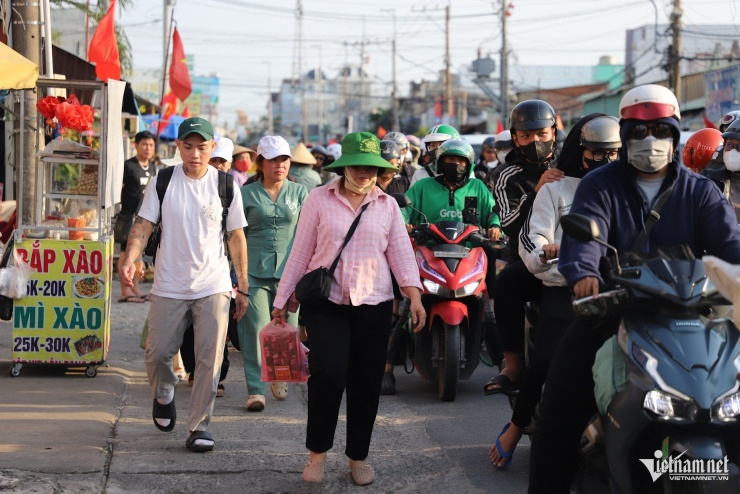 Nhiều người mất kiên nhẫn rời khỏi ô tô đang xếp hàng chờ đợi để đi bộ lên phà.