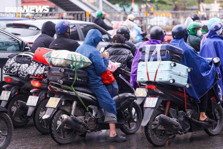 Sau kỳ nghỉ Tết, nhiều người trở lại Hà Nội với hành lý cồng kềnh, quà quê chất kín trên xe, tay xách nách mang giữa dòng phương tiện đông đúc.