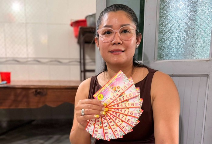 Chị Phương Lan vừa đổi thưởng cho khách hàng trúng độc đắc 10 vé Bình Dương. Ảnh: ĐLVS Lan Hùng Tú