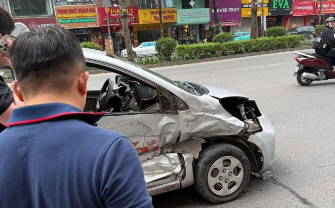 Taxi bẹp rúm phần hông sau va chạm chiều 23/2 trên phố Xã Đàn, Hà Nội. Ảnh: Xuân Hoa