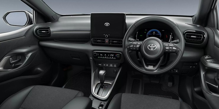 Nội thất trên Toyota Yaris (trái) và Yaris Cross 2026 (phải) có thiết kế tương đồng với bảng điều khiển trung tâm tối giản và hệ thống màn hình giải trí đặt nổi.