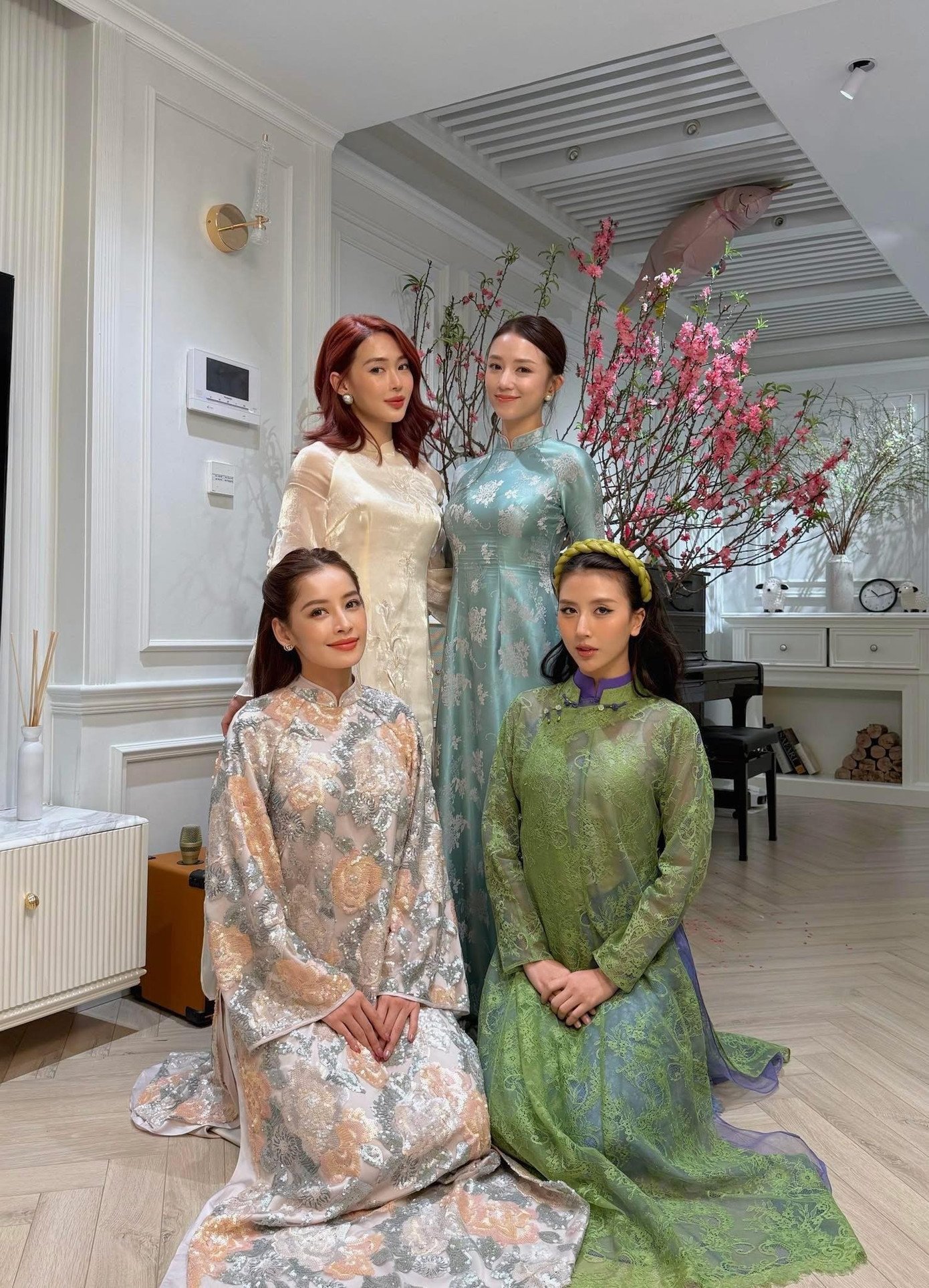 Trong bộ hình "hội ngộ" của bộ tứ hotgirl đình đám, Chi Pu nổi bật nhờ mẫu áo dài kim sa. Giáp Tết, nữ ca sĩ đã có bộ hình hưởng ứng xu hướng này, cô chọn mẫu áo dài cổ yếm đính kết tinh tế. Cả hai mẫu áo dài đều đến từ thương hiệu MERNE.