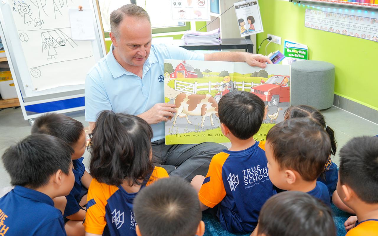 Hiệu trưởng Gerald Schoen đọc sách cùng học sinh tiểu học tại Ngày hội Đọc sách của trường