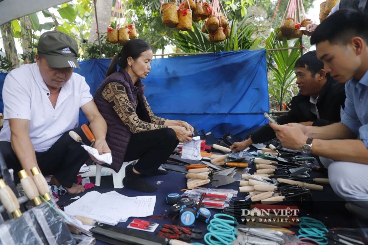 Bên cạnh tiếng băm chặt thịt bò, âm thanh đặc trưng làm nên nhịp điệu rộn rã của chợ Viềng chính là tiếng lanh canh của các gian hàng bán nông cụ. Những sạp hàng rèn thủ công bày biện đủ loại dao, cuốc, xẻng, liềm, cày, bừa... sáng loáng, sắc lẹm, phản chiếu dưới ánh đèn bạt ngàn.