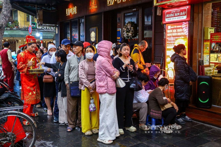 Tại 1 cửa hàng vàng nằm trên phố Trần Nhân Tông, ngay từ sáng sớm, hàng trăm người dân đã đội mưa xếp hàng chờ mua vàng trước ngày vía Thần tài.