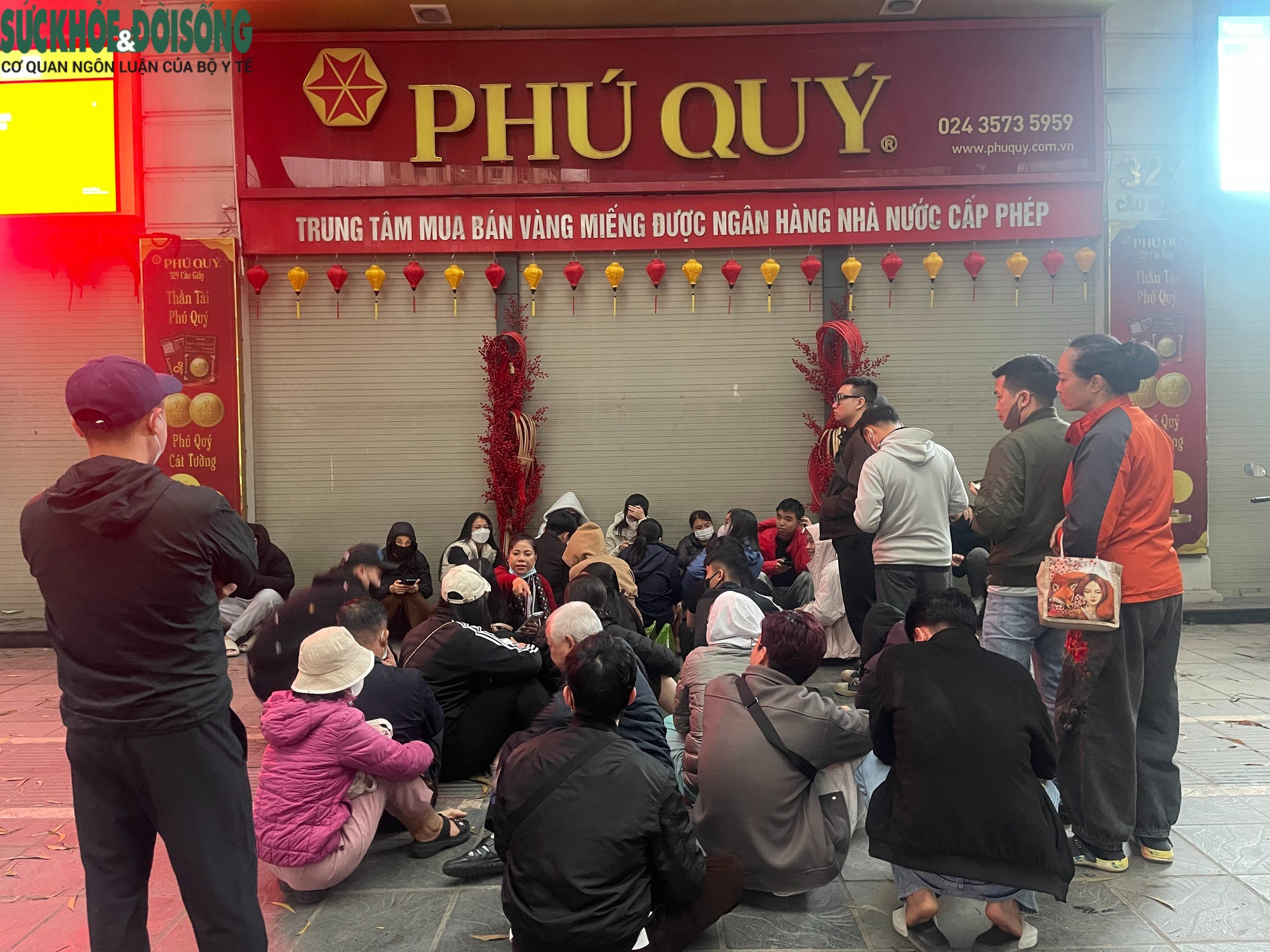 Trước cửa một điểm kinh doanh vàng bạc khác trên phố Cầu Giấy, lúc 6h30 hàng chục người ngồi sát vỉa hè, kiên nhẫn xếp hàng chờ mua vàng, bạc.