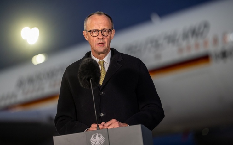 Thủ tướng Đức Merz phát biểu trước khi lên máy bay để bay sang Trung Quốc, ngày 24/2. Ảnh: DPA, AP.